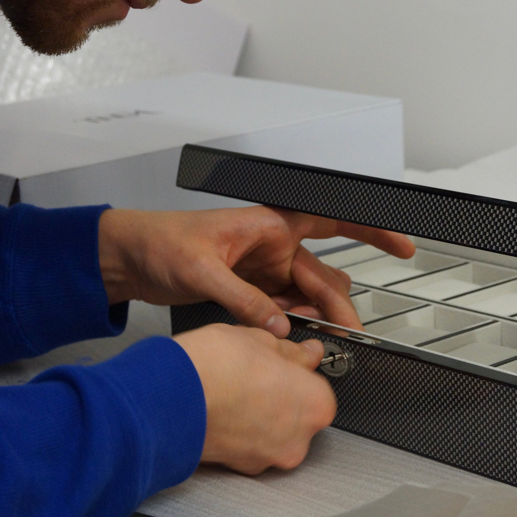 Man opening the Carbo Blanc 10 slot watch box via the secure key lock