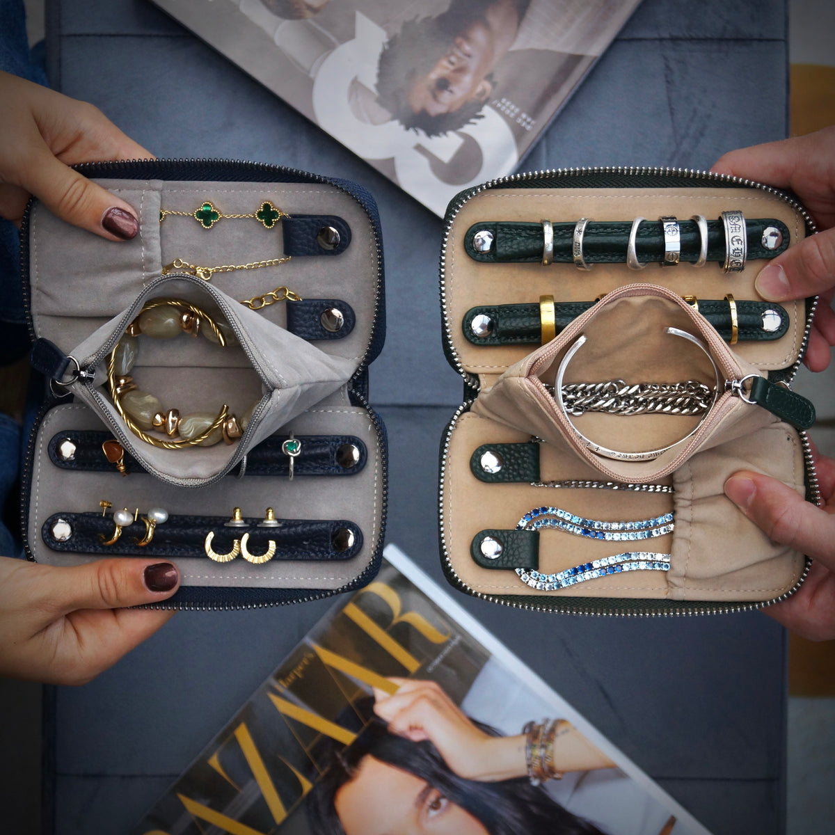 Two jewellery cases open, displaying necklaces and bracelets on a magazine background.
