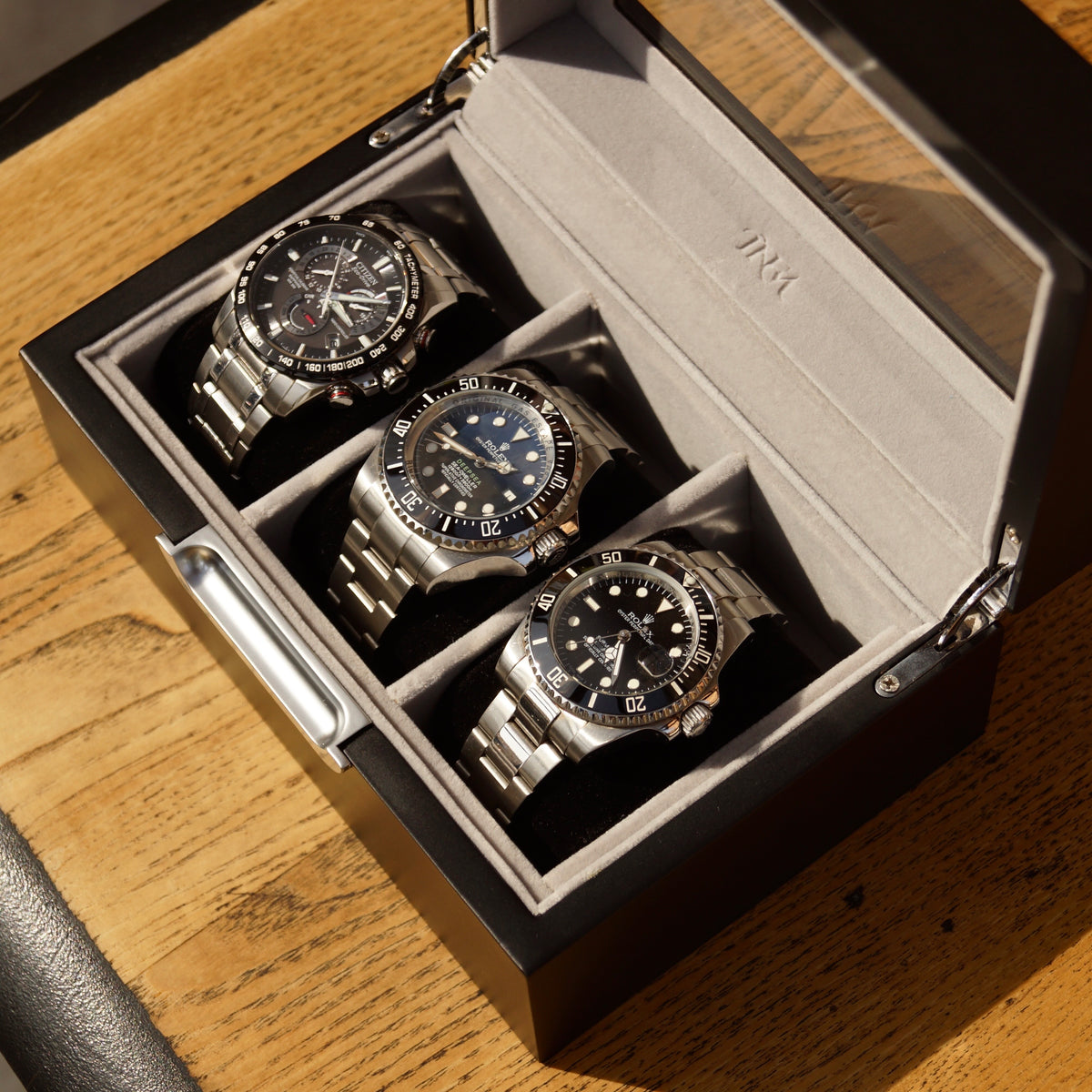 Bird’s-eye angled view of the LDN III men’s 3-slot grey watch box by Transform, shown open with three watches placed inside.
