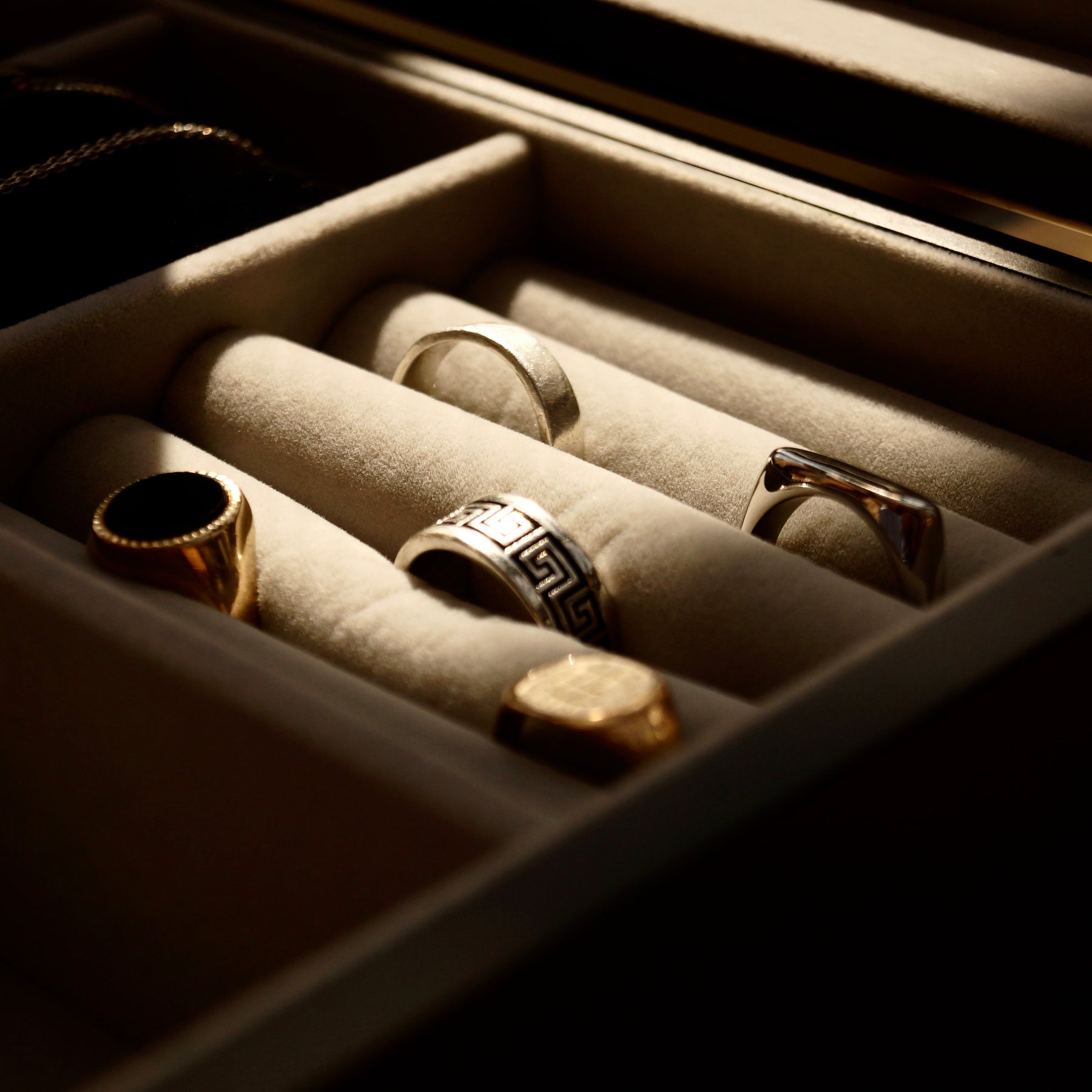 Close-up of the jewellery compartment in the LDN IV men’s 4-slot black watch box by Transform, showing five rings neatly stored inside.