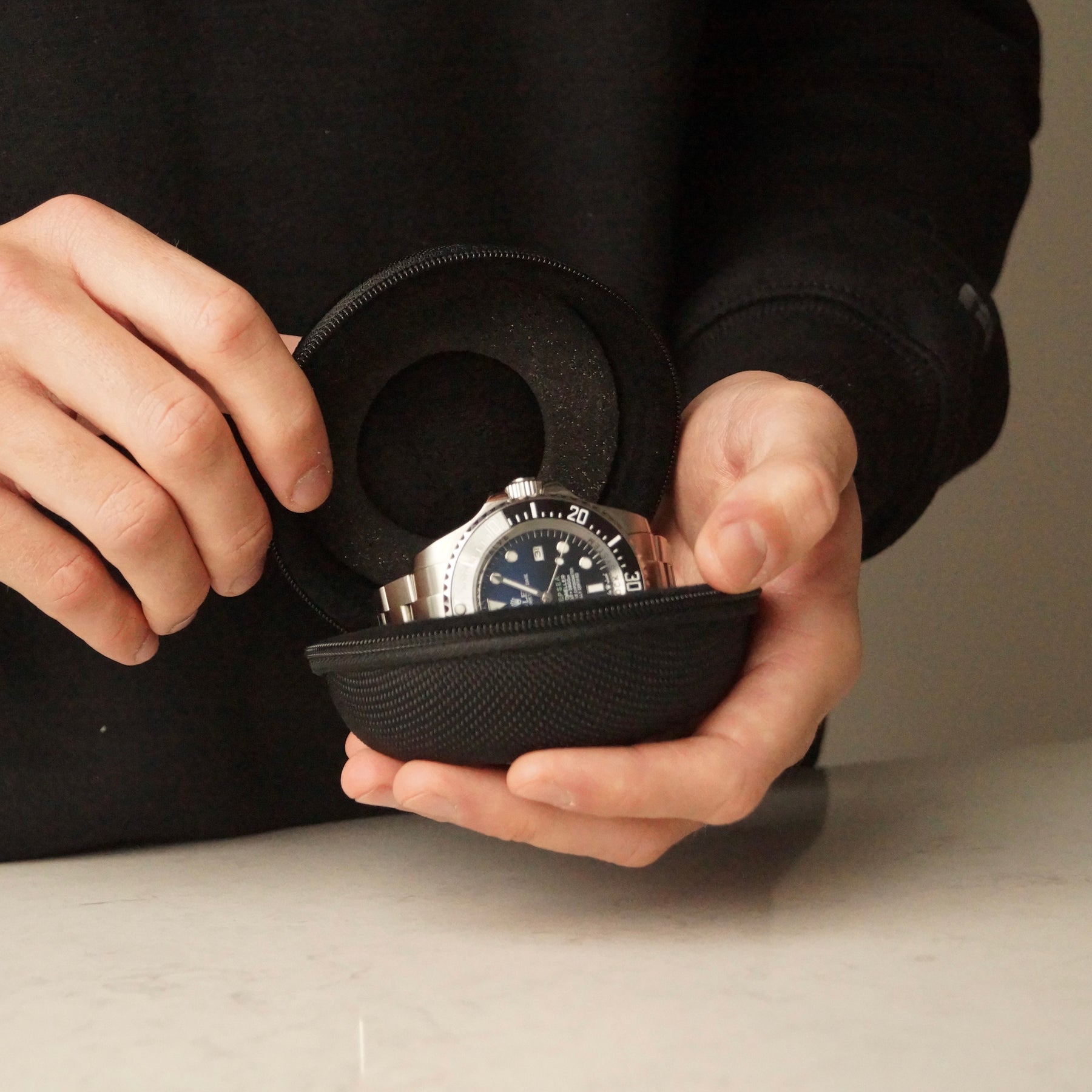Front-angled lifestyle image of the Solo Explorer single watch case by Transform, held in a man’s hands with a watch inside.