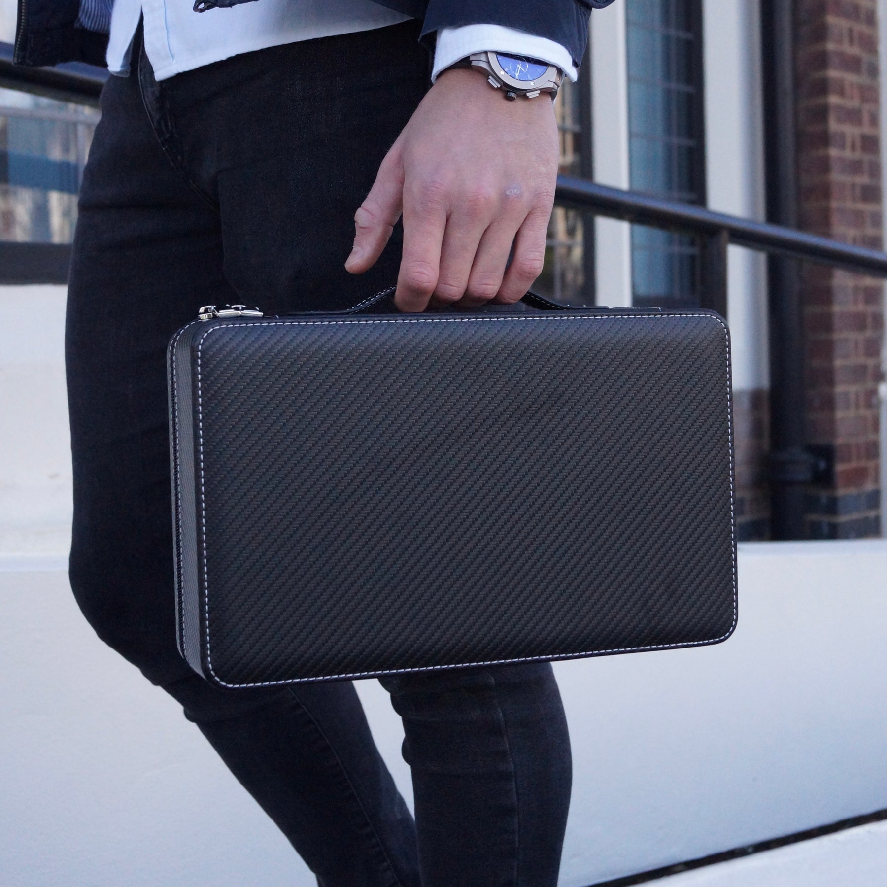 Side on lifestyle view of the Stealth X men’s 10-slot carbon watch case by Transform, held by a man from it’s carry handle.