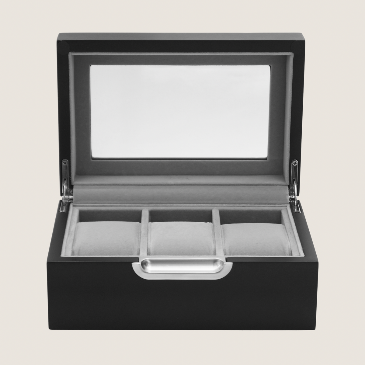 A black wooden watch box with an open hinged lid featuring a clear glass window and three interior watch slots, shown on a light beige background.