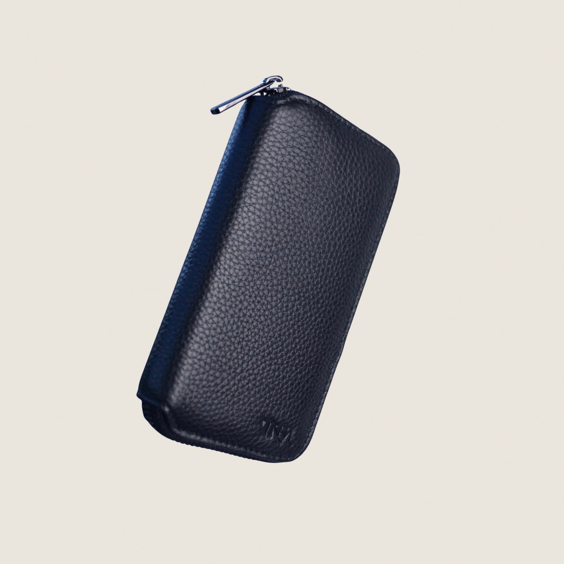 Front view of a compact black leather jewellery case with blank background.