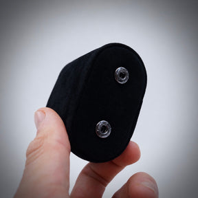 Close-up of a hand holding a black suede watch pillow from a watch roll.