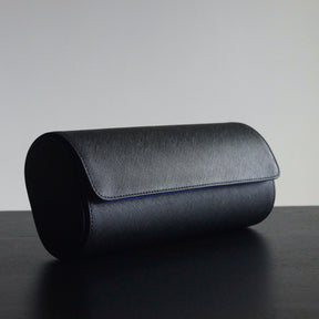 Side view of a leather 3-slot Transform watch roll closed on a table.