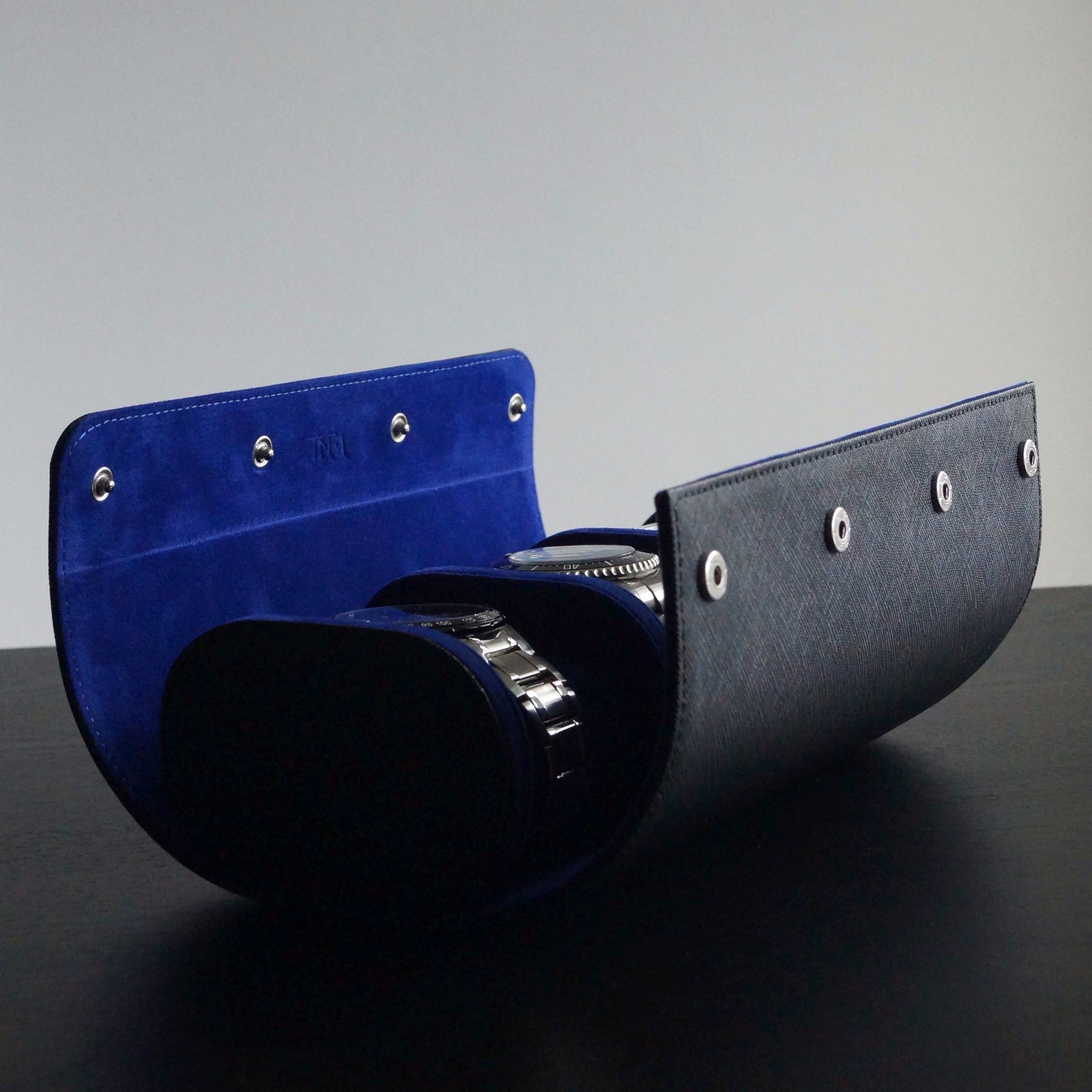 Side view of 3 watches inside a leather watch roll by Transform.