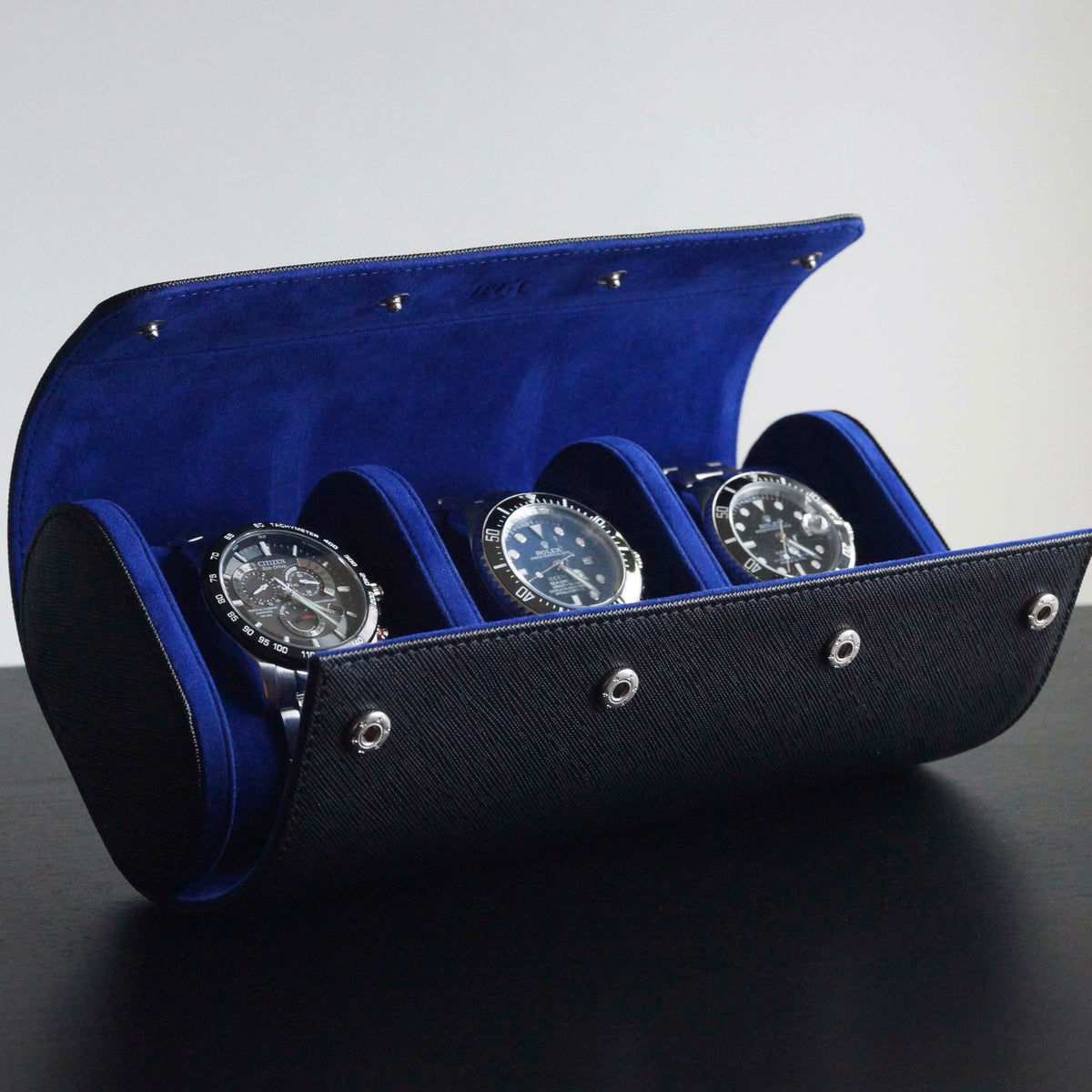 Side view of 3 watches inside a leather Transform watch roll.