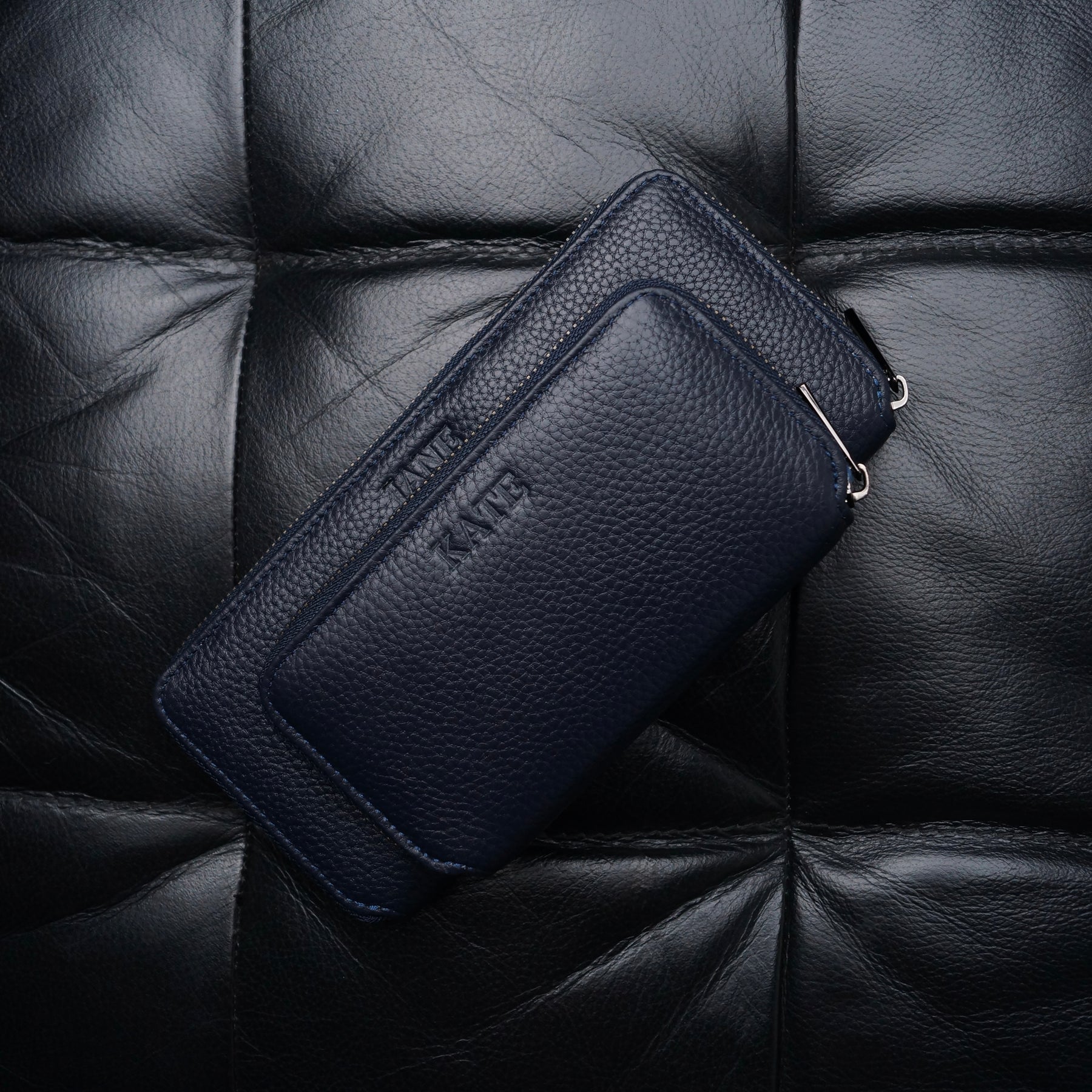 Two navy blue leather jewellery cases that have been personalised with names on them.