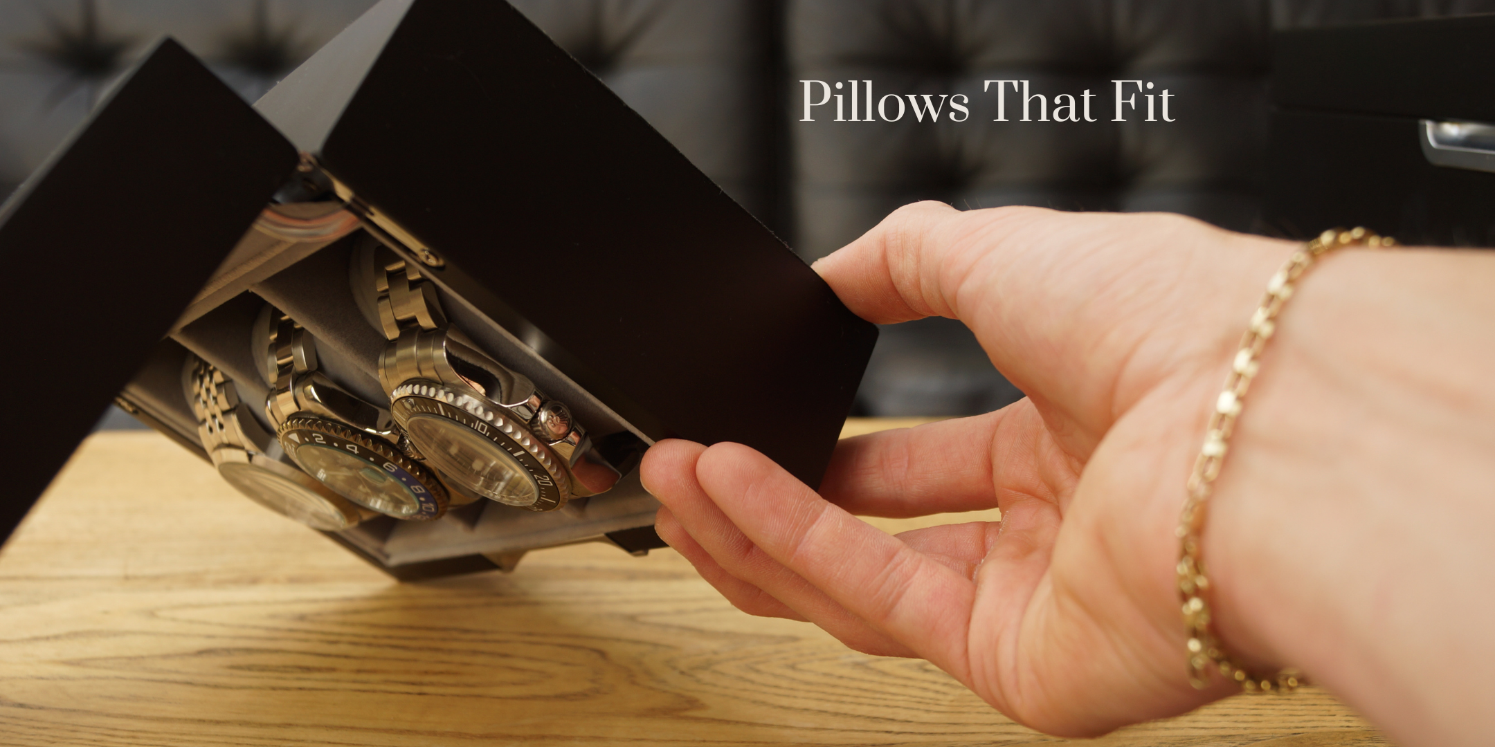 Landscape feature demonstration image of the LDN Ill men's 3-slot black watch box by Transform, shown being held upside down by a man while filled with watches, to display how the pillows fit snugly and securely in their slots. Text overlay reads 'Pillows that fit.’