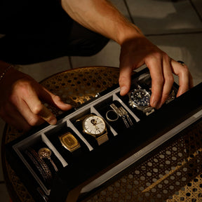 Person taking a watch out of a 6 slot watch box.