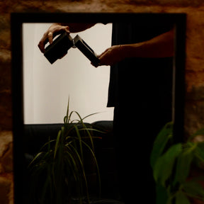 Feature demonstration of the LDN VI men’s 6-slot black watch box by Transform, shown being turned upside down by a man while filled with watches, to display how the pillows fit securely and keep the watches in place.