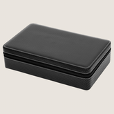 A rectangular black zippered 10-slot watch case with a carbon fiber textured pattern on the sides and a smooth black faux-leather top, shown on a light beige background.