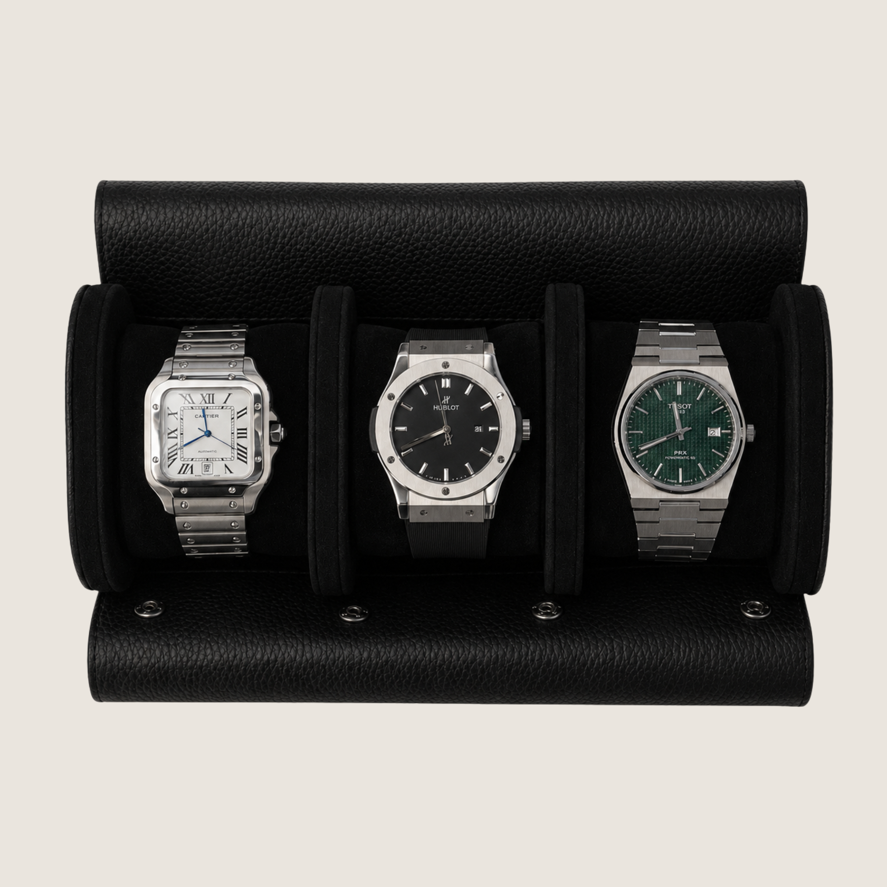 Three wristwatches displayed side-by-side in a black leather watch roll against a light beige background.