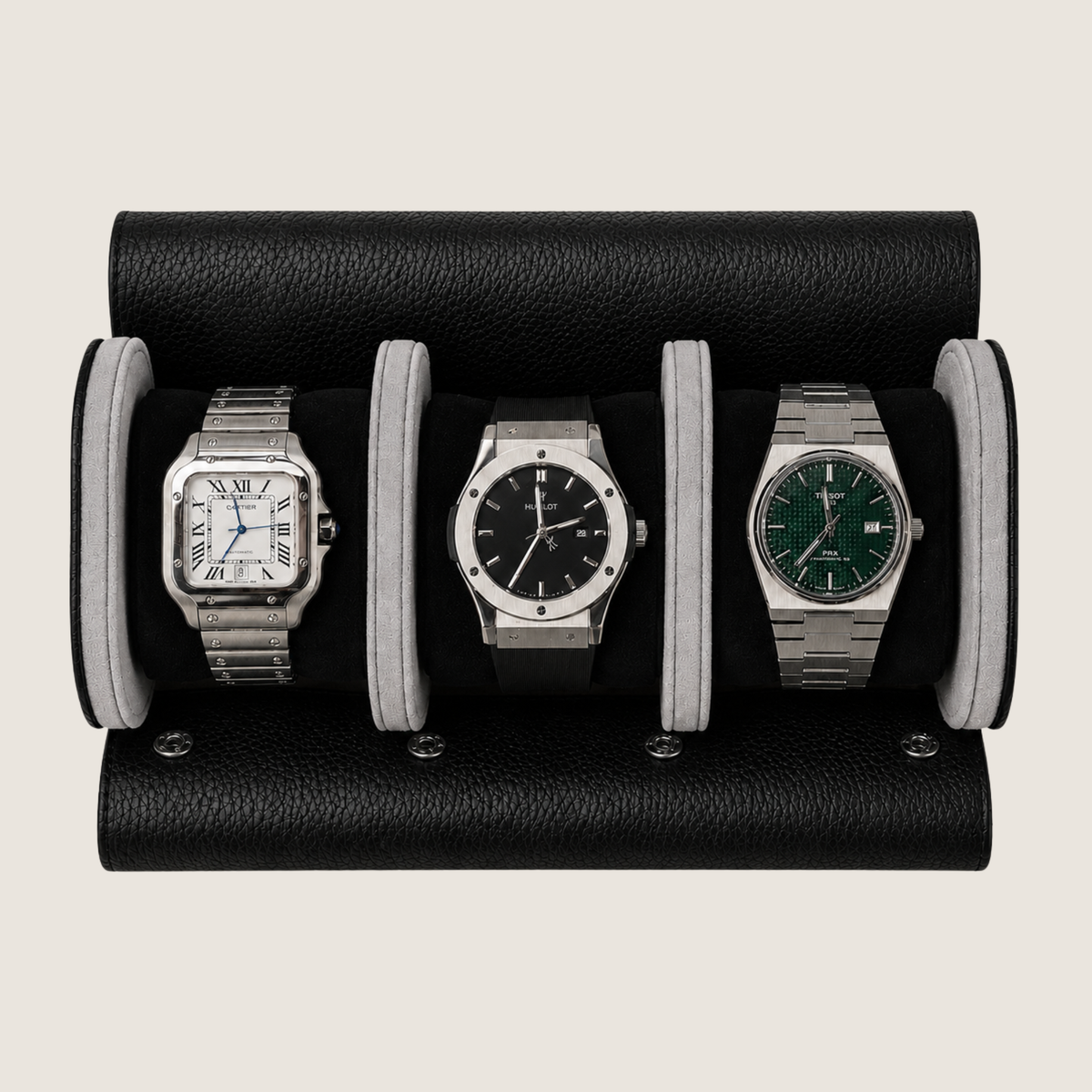 A black pebbled leather watch roll holding three wristwatches side by side on a light beige background.