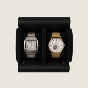 Two wristwatches displayed side-by-side in a black textured leather watch roll.