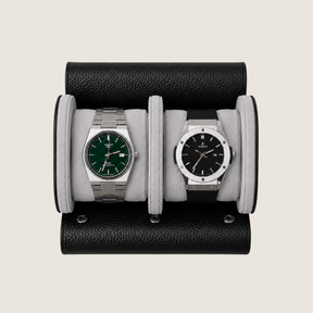A two-watch wristwatch display stand made of black pebbled leather with light grey suede cushions.